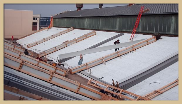 Uncrating metal roofing panels prior to installation and mechanical seaming.